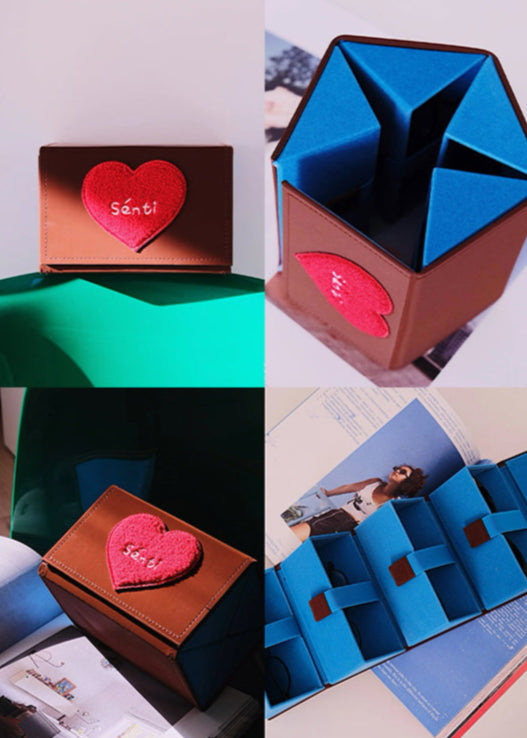 Brown box-shaped glasses case with red heart patch and vivid blue sides