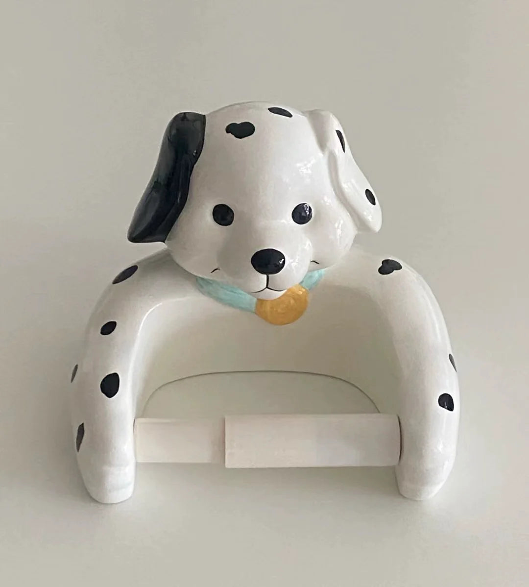 Adorable resin dog holding paper roll on kitchen wall
