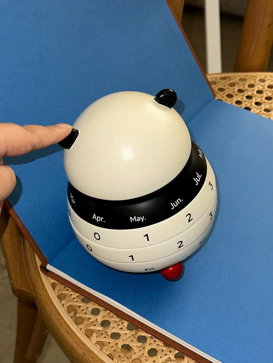 Hand turning panda calendar for date selection
